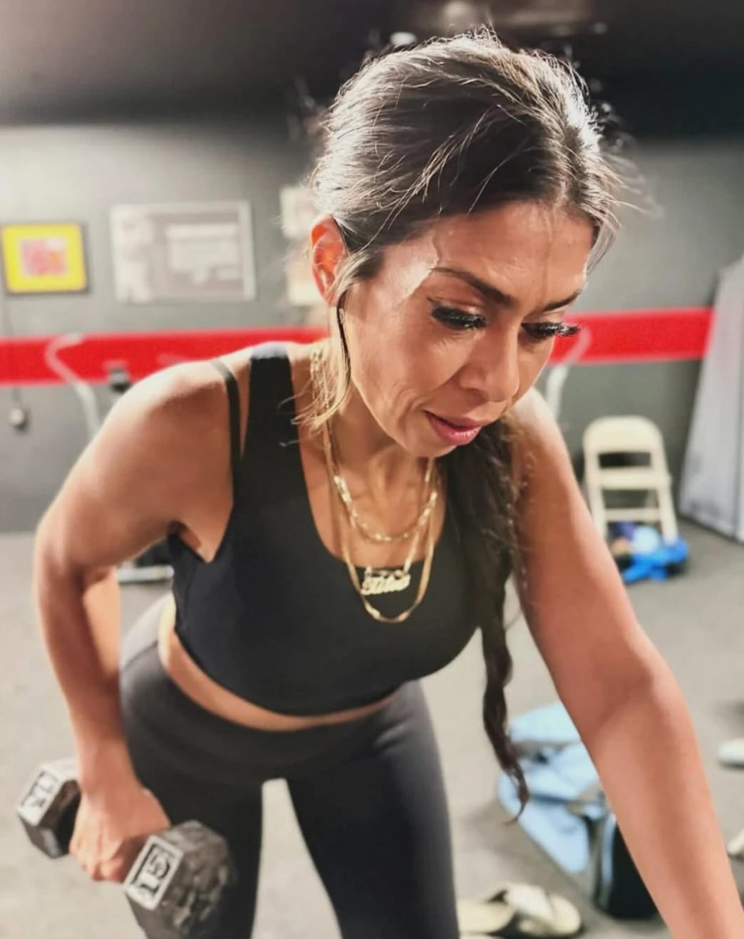 Beatriz mid dumbbell row in a gym